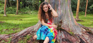Juliana Hamon in front of a rainbow eucalyptus tree